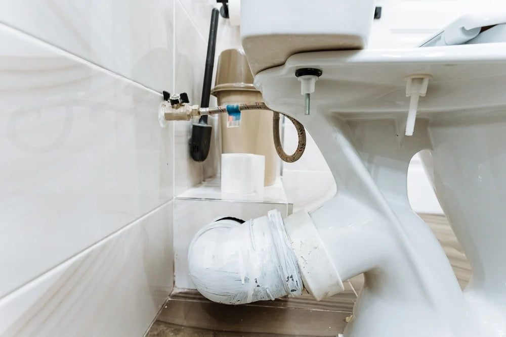 Visible drainage beneath the toilet, pvc piping system